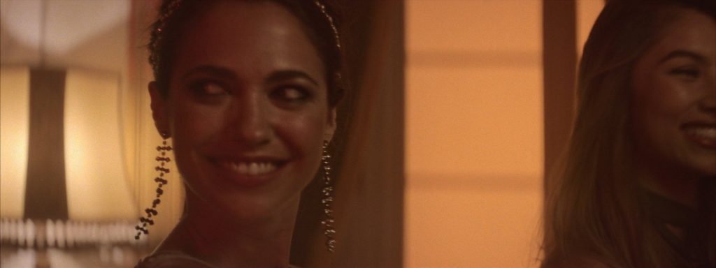 Sweet Matitos fashion film still: the party, with a woman in a headband smiling