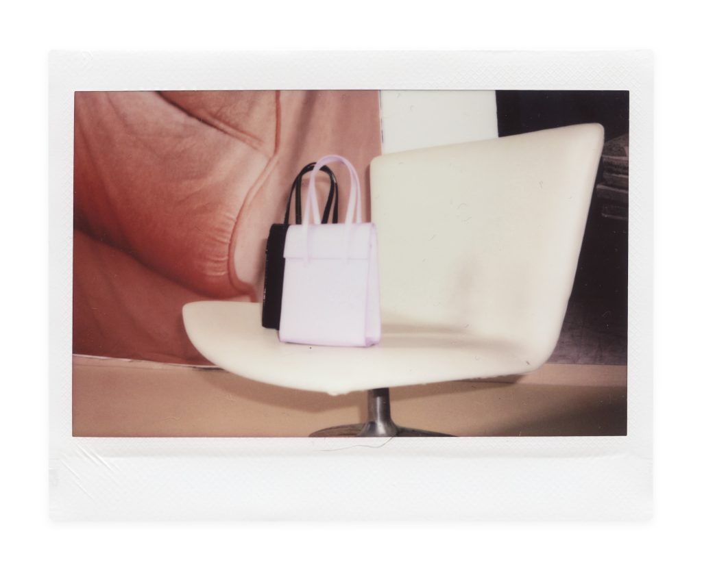 Blame Lilac Poderío: Instax of a black bag and a lilac bag on a white chair