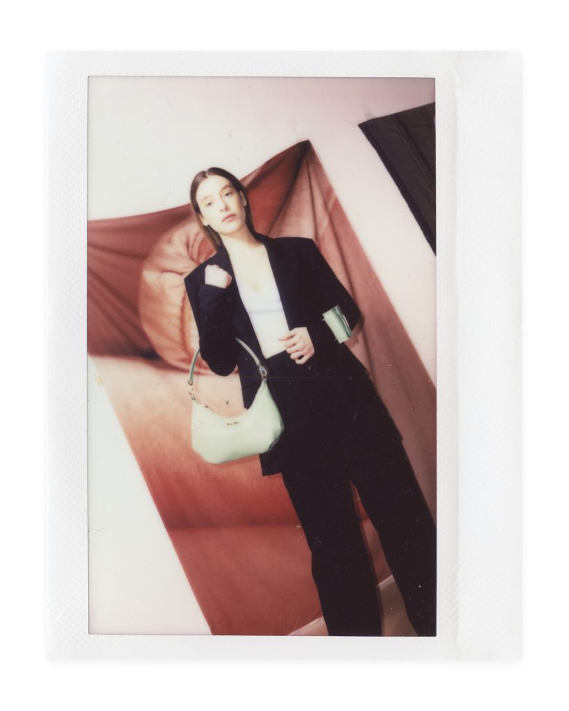 Blame Lilac Poderío: Instax of the model in a black suit with a green bag