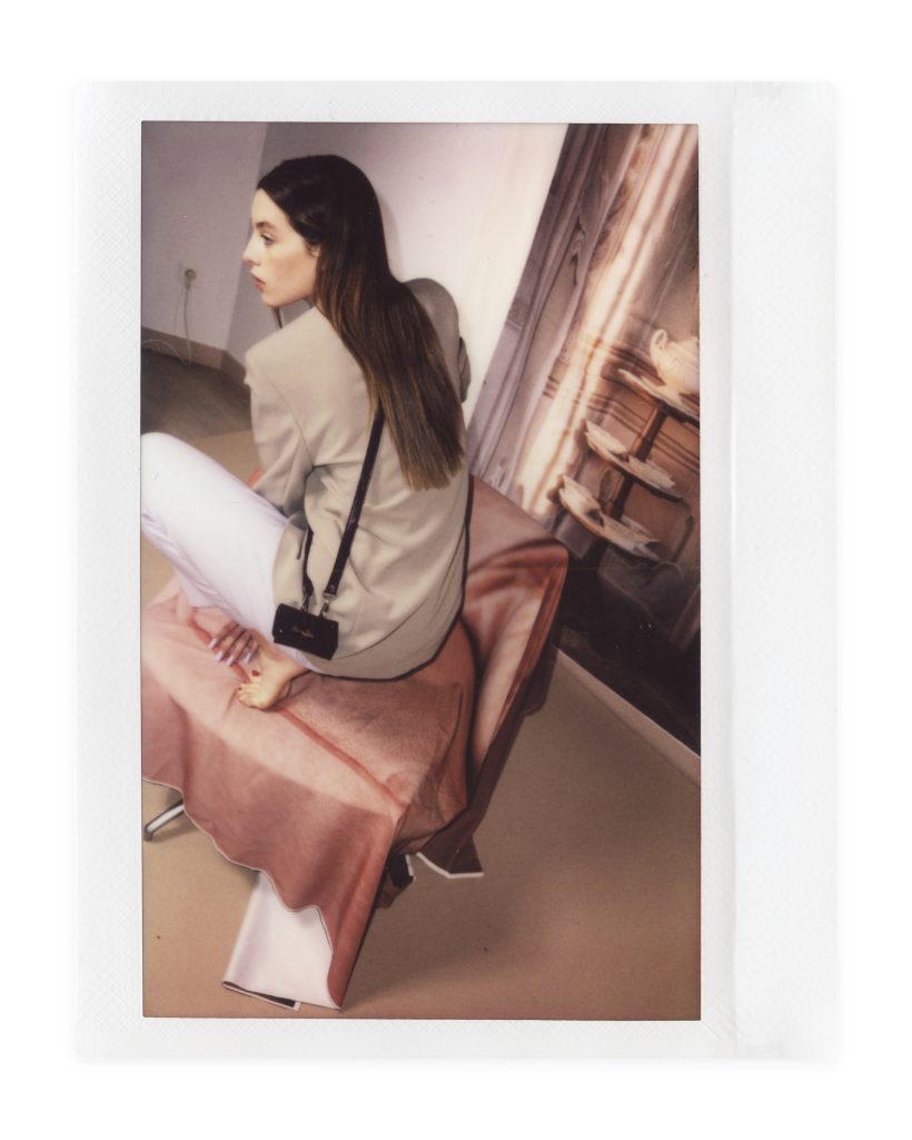 Blame Lilac Poderío: Instax of the model in a beige suit with a black crossbody bag