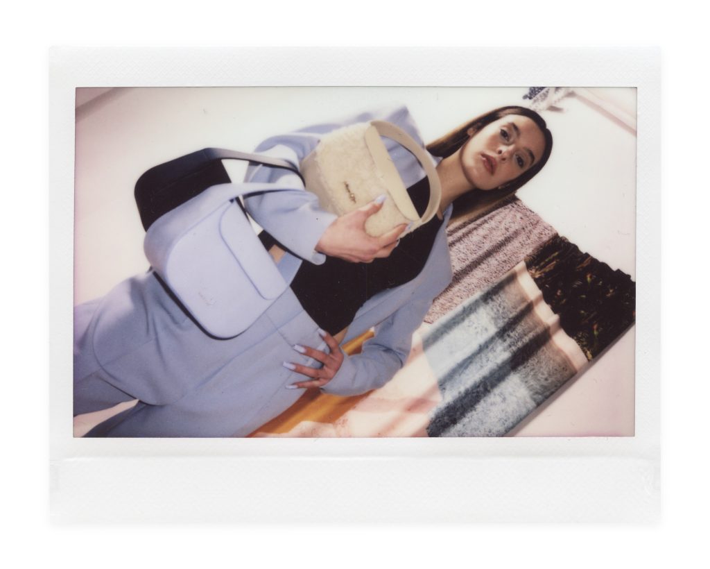 Blame Lilac Poderío: Instax of the model in a lilac suit with lilac and cream bags