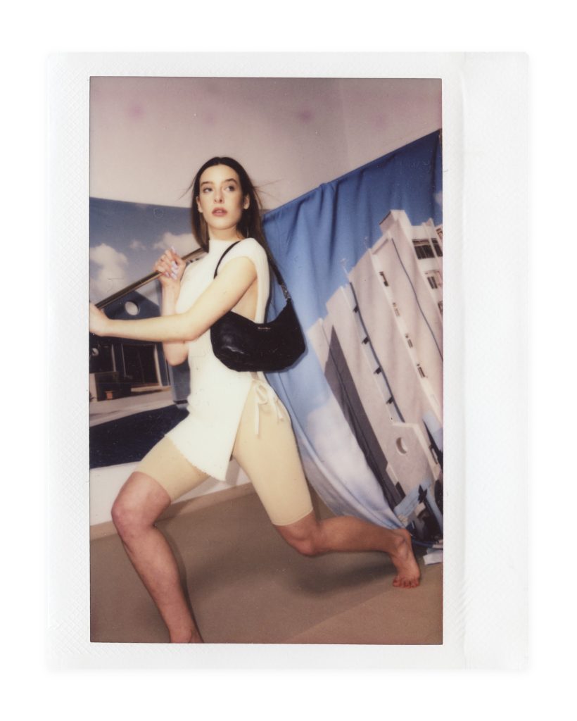 Blame Lilac Poderío: Instax of the model in a white dress with a black bag