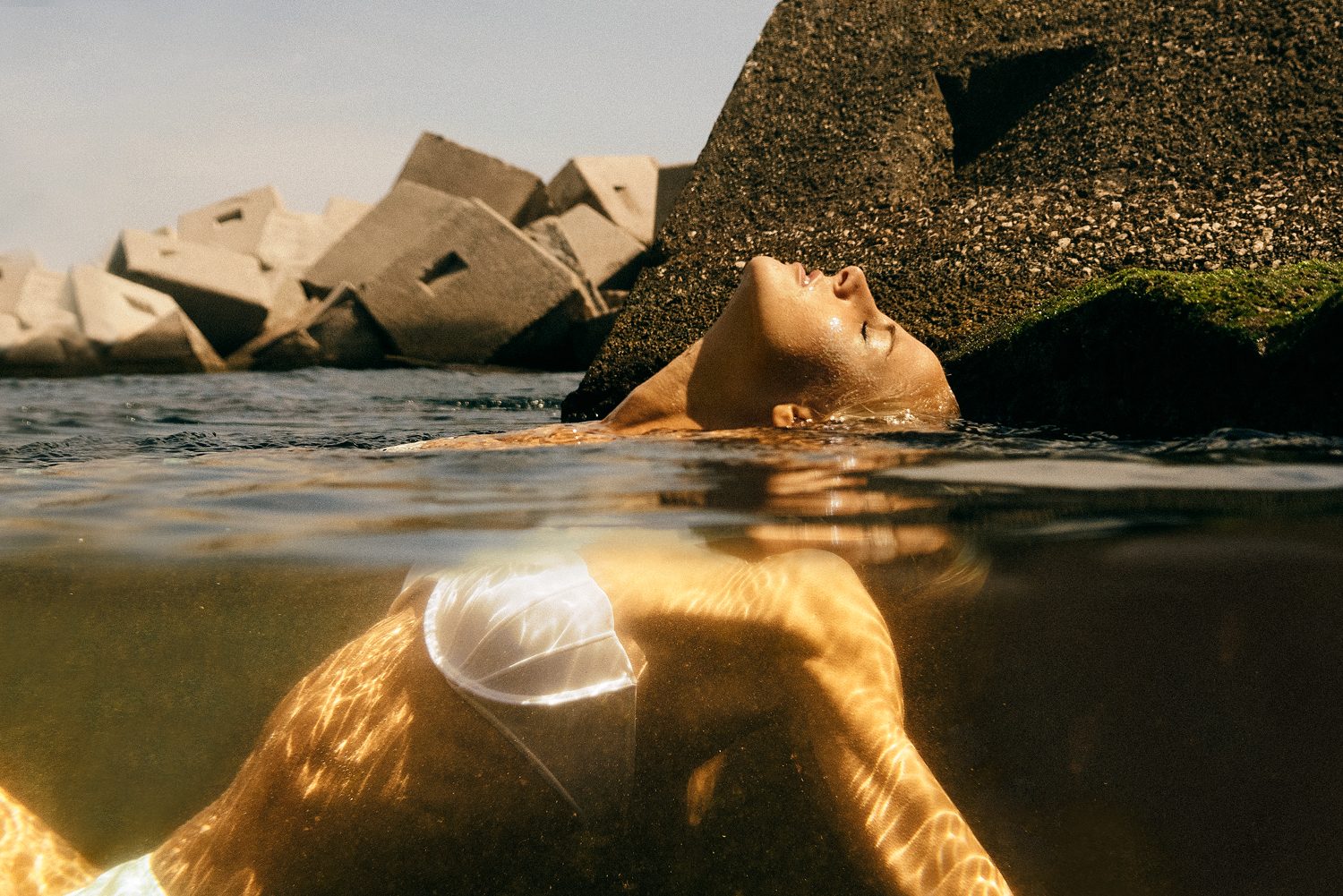 Grain Supply: model floating face up next to the blocks of a breakwater, seen at the waterline