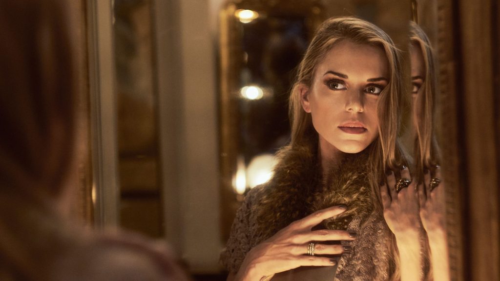 Marcela Ruete in a fur stole next to a mirror