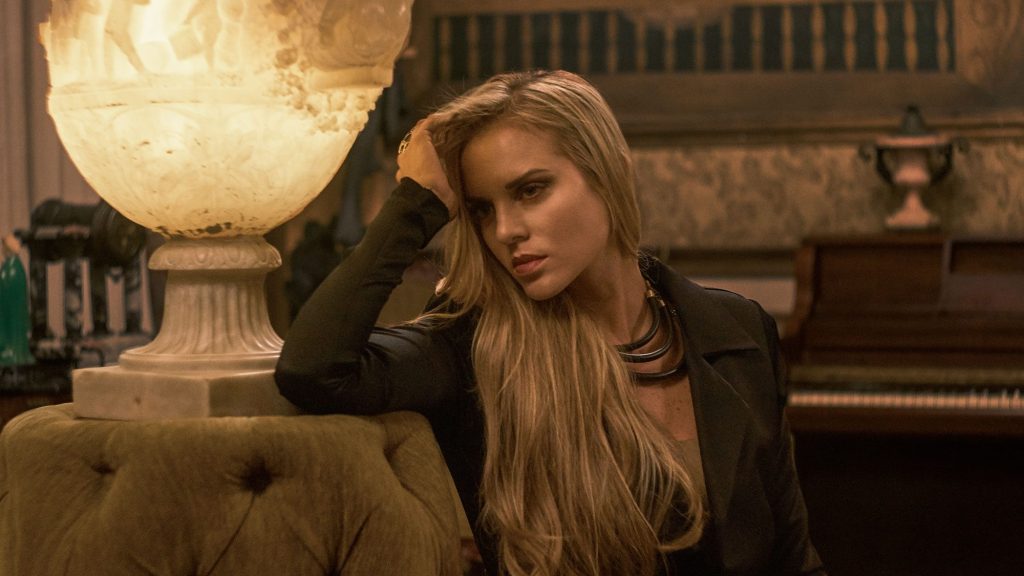 Marcela Ruete leaning on an armchair next to a lamp