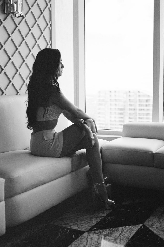 Marcelle sitting on a sofa by a window, black and white